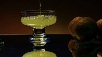 proche en haut de verser Orange un soda dans le verre. Stock clop. doux boisson avec le goût de agrumes et Orange des fruits sur le réfléchissant table surface. photo