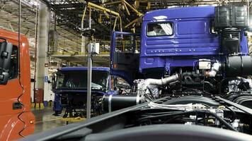 voiture Assemblée ligne production à le kamaz un camion usine. scène. temps laps effet, industriel Contexte avec corps Cadre pendaison doubler, mécanique ingénierie concept. photo