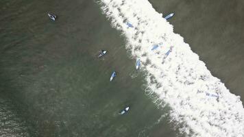 un aérien vue de surfeurs attendre pour une vague dans le océan sur une clair journée. aérien vue de surfeur sur énorme Indien océan vague. surfeurs sur le plage Haut vue photo