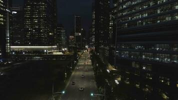 Haut vue de rue avec voitures et moderne bâtiments dans gros chinois ville à nuit. tir. nuit aérien vue de ville centre avec ses route, en mouvement voitures, lumières de grattes ciels, nuit la vie concept. photo