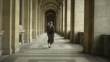 retour vue de sexy Jeune femme en marchant vieux bâtiment. action. attrayant Jeune femme dans de façon séduisante révélateur transparent robe est modèle démarche le long de couloir de vieux bâtiment photo