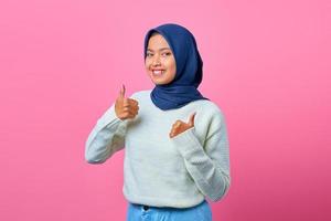 portrait d'une belle femme asiatique souriante montrant des pouces vers le haut ou un signe d'approbation photo