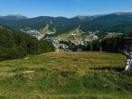 été aérien vue de montagnes ski station balnéaire, village dans le montagnes, la nature beauté. chalets à une ski recours avec clair ensoleillé temps et Montagne vues photo