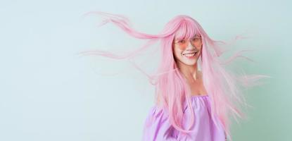 jeune femme asiatique aux cheveux roses posant sur fond vert photo