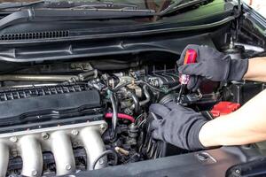 technicien utilisation Tournevis retirer une boulon de flux d'air capteur dans le moteur pièce voiture pour vérifier et nettoyage dans un service concept photo