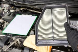 main une homme changement et vérifier vieux air filtre de voiture dans le moteur pièce photo