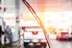 bulle sur le verre le pare-brise essuie-glaces de voiture laver et nettoyage dans gaz station photo