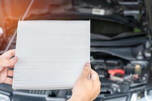 technicien vérification poussière sur une Nouveau air filtre de air conditionnement système en dehors site voiture un service et entretien concept de un service voiture photo