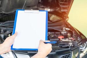 des employés homme de le voiture un service centre vérification liste sur le papier Remarque pour entretien et un service voiture photo