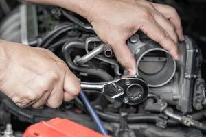 main une homme tenir clé dans voiture un service moteur Manette de Gaz soupape nettoyage et entretien voiture un service concept photo