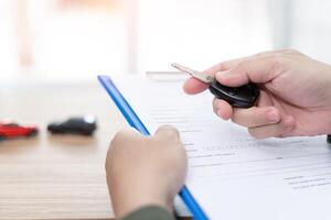 proche en haut main une homme en portant éloigné contrôle de voiture et les documents voiture Assurance concept photo