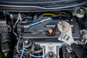 un service concept de voiture technicien est en utilisant une Ajustable clé pour réparation voiture dans garage photo