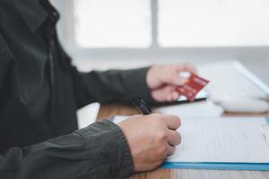 une homme vérifier nombre de crédit carte et blanc dans document dans fabrication financier les documents photo