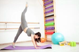 femme fait du pont avec verticale ficelle jambes, gymnaste dans Gym photo