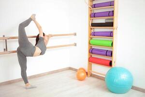 Jeune femme est Faire gymnastique dans salle de sport. en bonne santé mode de vie. ballet photo