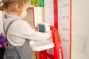 une petit deux ans fille pièces avec jouets dans le salle de jeux photo