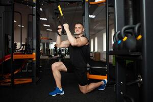 une magnifique entraîneur effectue des exercices sur simulateur, squats, des pompes sur lester, musclé corps. athlète dans le salle de sport, encadrement, individuel poids perte cours, des sports, publicité. presse photo