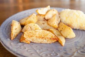 cuit patates avec herbes et côtelettes dans panure avec fromage et beurre. nourriture sur une assiette dans une café. petit-déjeuner, déjeuner, dîner à le restaurant. casse-croûte photo