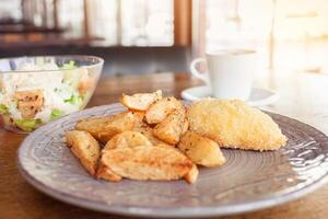 petit-déjeuner, dîner, le déjeuner dans une restaurant, café. cuit patates avec Boulettes de viande, César salade, café américain. intervieweur, délicieux nourriture, grand les fenêtres, Naturel lumière du soleil. flou Contexte photo