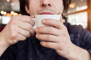 une homme les boissons café dans une café, une restaurant. intérieur, Naturel lumière du soleil, flou arrière-plan, de côté. collation, petit déjeuner. le déjeuner Pause. photo