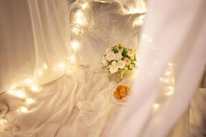 doux plaids sur le herbe, bouquet avec des roses, assiette avec des croissants, blanc canopée sur le arbre. soir photo zone