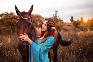 magnifique Jeune femelle elfe avec longue foncé ondulé cheveux caresse sa cheval repos dans le les bois forêt nymphe caressant sa cheval se soucier animal de compagnie l'amour animaux harmonie soins propriétaire doux créature mythe photo