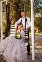 mariage couple dans le les bois sur une balançoire. Jeune gens dans l'amour l'amour avec chaque autre. photo