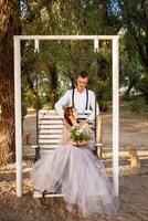 mariage couple dans le les bois sur une balançoire. Jeune gens dans l'amour l'amour avec chaque autre. photo