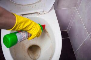 Femme de ménage avec caoutchouc gant nettoyage robinet et couler. photo
