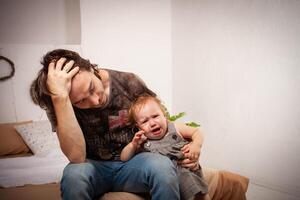 le enfant est en hurlant, hystérique. une fatigué papa ne fait pas vouloir à entendre le bébé. le parent est irrité, fatigué, veut à prendre une Pause de le sien fille. enfants hystérie. photo