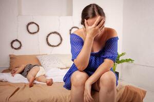 maman est fatigué de le bébé, veut à du repos et dormir. le enfant cris, hystérique. le femme est fatigué de le enfant pleurer, elle Est-ce que ne pas vouloir à entendre. une Un an fille crie de une mal aux dents. photo