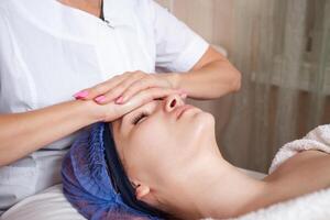 le esthéticien massages le visage dans le beauté salon photo