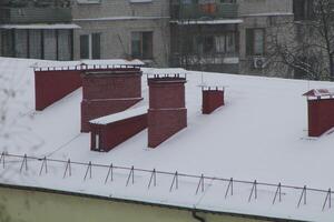 toits et cheminées couvert avec neige dans hiver photo