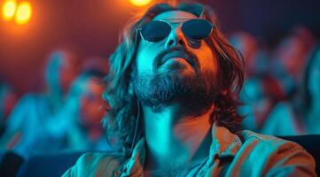 ai généré Jeune homme avec longue cheveux et barbe avec des lunettes de soleil et des lunettes en train de regarder film dans cinéma photo