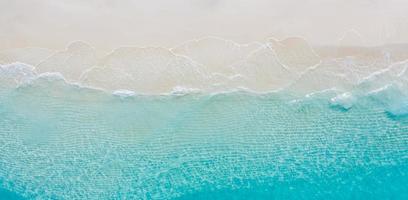 paysage marin d'été belles vagues, eau de mer bleue en journée ensoleillée. vue de dessus du drone. vue aérienne de la mer, fond de nature tropicale incroyable. belle mer lumineuse avec des vagues éclaboussant et concept de sable de plage photo