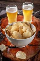 croustilles dans un bol avec deux verres de bière photo