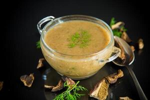 chaud fait maison légume végétarien soupe avec séché champignons dans une verre bol photo