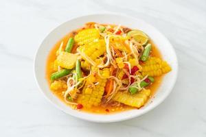 som tum - salade de papaye épicée thaï au maïs photo