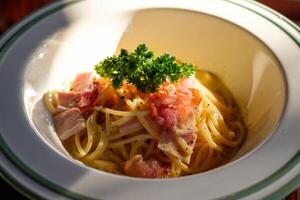 spaghetti carbonara avec bacon, jambon et légume dans bol photo