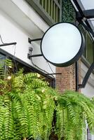 Vide rond magasin signe lumière boîte pendaison sur rétro café avec plante feuilles photo