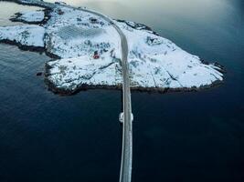 aérien vue de route pont plus de neigeux île avec scandinave maison sur hiver dans archipel à lofoten îles photo