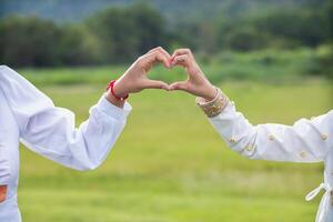 amoureux soulève sa mains et fait du cœur symbole Express sens de l'amour relation amicale et la gentillesse vers sa ami et amoureux. couple les usages leur mains à faire cœur symbole cette veux dire l'amour et amitié. photo