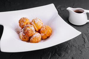 Profiteroles avec en poudre sucre et Chocolat crème photo