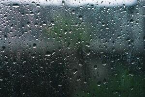 pluvieux journées pluie gouttes sur le fenêtre surface. Contexte et texture de humide fenêtre avec pluvieux gouttes photo