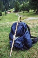 une sac à dos et une bâton séance sur le herbe photo