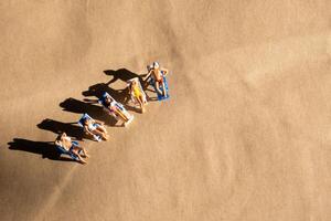 miniature gens séance une banc sur le plage, sélectif concentrer et espace pour Contexte photo