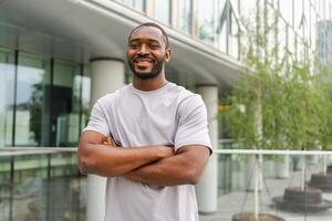 content africain américain homme souriant Extérieur. portrait de Jeune content homme sur rue dans ville. de bonne humeur joyeux Beau la personne gars à la recherche à caméra. liberté bonheur insouciant content gens concept photo