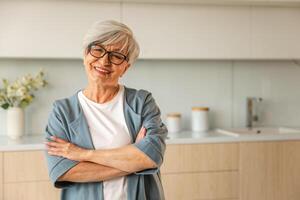 portrait de sur de soi élégant européen milieu vieilli Sénior femme. plus âgée mature Années 60 Dame souriant à maison. content attrayant Sénior femelle à la recherche caméra proche en haut visage photo du visage portrait. content gens