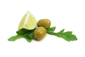 deux olives, morceau de citron et feuilles de roquette isolated on white photo
