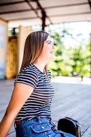 portrait en gros plan d'une belle jeune femme de race blanche souriante et regardant à l'extérieur par une journée ensoleillée photo
